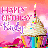 A vibrant birthday GIF featuring a rainbow-colored cupcake topped with white frosting, sprinkles, and a lit candle. The text reads 'Happy Birthday Keidy' in bold pink and violet letters with white outline.