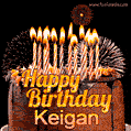 A rich chocolate cake topped with glowing birthday candles and surrounded by bright fireworks. The animated GIF displays the message 'Happy Birthday Keigan' in golden text.