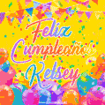 A bright and festive GIF with the text 'Feliz Cumpleaños Kelsey' in Spanish in colorful fonts, surrounded by confetti, balloons, and festive banners on a vibrant yellow background.