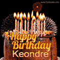A rich chocolate cake topped with glowing birthday candles and surrounded by bright fireworks. The animated GIF displays the message 'Happy Birthday Keondre' in golden text.