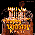 A rich chocolate cake topped with glowing birthday candles and surrounded by bright fireworks. The animated GIF displays the message 'Happy Birthday Keyan' in golden text.