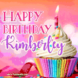 A vibrant birthday GIF featuring a rainbow-colored cupcake topped with white frosting, sprinkles, and a lit candle. The text reads 'Happy Birthday Kimberley' in bold pink and violet letters with white outline.