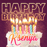 A colorful birthday cake topped with lit candles, with the words 'Happy Birthday Ksenija' in bold glowing letters on a burgundy background. Animated flames add a festive touch.