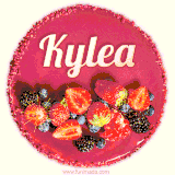 Beautifully decorated red velvet berry birthday cake with vibrant fruits and a glowing 'Kylea' name, adding a touch of sweetness and sparkle.