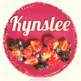 Beautifully decorated red velvet berry birthday cake with vibrant fruits and a glowing 'Kynslee' name, adding a touch of sweetness and sparkle.
