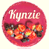 Beautifully decorated red velvet berry birthday cake with vibrant fruits and a glowing 'Kynzie' name, adding a touch of sweetness and sparkle.