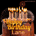 A rich chocolate cake topped with glowing birthday candles and surrounded by bright fireworks. The animated GIF displays the message 'Happy Birthday Lane' in golden text.