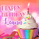 A vibrant birthday GIF featuring a rainbow-colored cupcake topped with white frosting, sprinkles, and a lit candle. The text reads 'Happy Birthday Leann' in bold pink and violet letters with white outline.