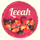 Beautifully decorated red velvet berry birthday cake with vibrant fruits and a glowing 'Leeah' name, adding a touch of sweetness and sparkle.