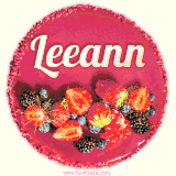 Beautifully decorated red velvet berry birthday cake with vibrant fruits and a glowing 'Leeann' name, adding a touch of sweetness and sparkle.