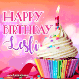 A vibrant birthday GIF featuring a rainbow-colored cupcake topped with white frosting, sprinkles, and a lit candle. The text reads 'Happy Birthday Lesli' in bold pink and violet letters with white outline.