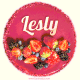 Beautifully decorated red velvet berry birthday cake with vibrant fruits and a glowing 'Lesly' name, adding a touch of sweetness and sparkle.