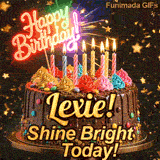 A rich chocolate frosted cake on a gold stand with glowing yellow candles, personalized with the name Lexie!
