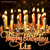 A glowing personalized birthday GIF with name Liz featuring lit candles with intricate designs, warm lighting, and the text 'Happy Birthday' in an elegant font.
