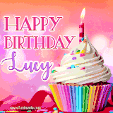 A vibrant birthday GIF featuring a rainbow-colored cupcake topped with white frosting, sprinkles, and a lit candle. The text reads 'Happy Birthday Lucy' in bold pink and violet letters with white outline.