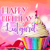 A vibrant birthday GIF featuring a rainbow-colored cupcake topped with white frosting, sprinkles, and a lit candle. The text reads 'Happy Birthday Lutgard' in bold pink and violet letters with white outline.