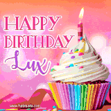 A vibrant birthday GIF featuring a rainbow-colored cupcake topped with white frosting, sprinkles, and a lit candle. The text reads 'Happy Birthday Lux' in bold pink and violet letters with white outline.