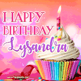 A vibrant birthday GIF featuring a rainbow-colored cupcake topped with white frosting, sprinkles, and a lit candle. The text reads 'Happy Birthday Lysandra' in bold pink and violet letters with white outline.