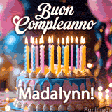 Birthday cake topped with pink and yellow lit candles, surrounded by glowing bokeh lights and party balloons. The greeting 'Buon Compleanno Madalynn GIF!' is displayed.