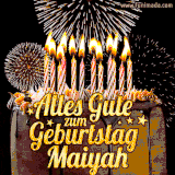 A chocolate birthday cake with glowing candles, the German text 'Alles Gute zum Geburtstag Maiyah,' and vibrant fireworks lighting up the background in an animated GIF.