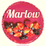 Beautifully decorated red velvet berry birthday cake with vibrant fruits and a glowing 'Marlow' name, adding a touch of sweetness and sparkle.