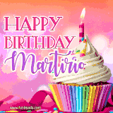 A vibrant birthday GIF featuring a rainbow-colored cupcake topped with white frosting, sprinkles, and a lit candle. The text reads 'Happy Birthday Martirio' in bold pink and violet letters with white outline.
