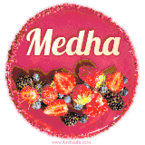Beautifully decorated red velvet berry birthday cake with vibrant fruits and a glowing 'Medha' name, adding a touch of sweetness and sparkle.