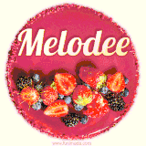 Beautifully decorated red velvet berry birthday cake with vibrant fruits and a glowing 'Melodee' name, adding a touch of sweetness and sparkle.