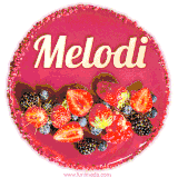 Beautifully decorated red velvet berry birthday cake with vibrant fruits and a glowing 'Melodi' name, adding a touch of sweetness and sparkle.