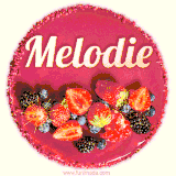 Beautifully decorated red velvet berry birthday cake with vibrant fruits and a glowing 'Melodie' name, adding a touch of sweetness and sparkle.