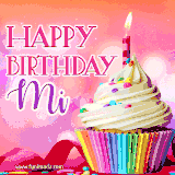 A vibrant birthday GIF featuring a rainbow-colored cupcake topped with white frosting, sprinkles, and a lit candle. The text reads 'Happy Birthday Mi' in bold pink and violet letters with white outline.