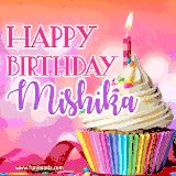 A vibrant birthday GIF featuring a rainbow-colored cupcake topped with white frosting, sprinkles, and a lit candle. The text reads 'Happy Birthday Mishika' in bold pink and violet letters with white outline.