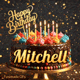 Bright candles flickering on a festive chocolate cake with the name Mitchell displayed in golden letters.