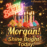 Yellow script spelling the name Morgan! on a classic chocolate cake under warm glowing candles and falling gold stars.
