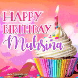 A vibrant birthday GIF featuring a rainbow-colored cupcake topped with white frosting, sprinkles, and a lit candle. The text reads 'Happy Birthday Muhsina' in bold pink and violet letters with white outline.