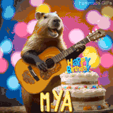 Animated birthday GIF showing a capybara playing guitar and singing beside a birthday cake with the name Mya in large letters and colorful bokeh lights in the background.