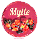 Beautifully decorated red velvet berry birthday cake with vibrant fruits and a glowing 'Mylie' name, adding a touch of sweetness and sparkle.