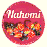 Beautifully decorated red velvet berry birthday cake with vibrant fruits and a glowing 'Nahomi' name, adding a touch of sweetness and sparkle.