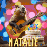 Animated birthday GIF showing a capybara playing guitar and singing beside a birthday cake with the name Natalie in large letters and colorful bokeh lights in the background.