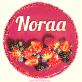 Beautifully decorated red velvet berry birthday cake with vibrant fruits and a glowing 'Noraa' name, adding a touch of sweetness and sparkle.
