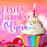 A vibrant birthday GIF featuring a rainbow-colored cupcake topped with white frosting, sprinkles, and a lit candle. The text reads 'Happy Birthday Olyvia' in bold pink and violet letters with white outline.