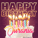 A colorful birthday cake topped with lit candles, with the words 'Happy Birthday Ourania' in bold glowing letters on a burgundy background. Animated flames add a festive touch.