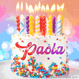 A cheerful white birthday cake with multicolor sprinkles, lit candles, and 'Paola' written in vibrant letters, in an animated GIF.