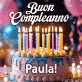 Birthday cake topped with pink and yellow lit candles, surrounded by glowing bokeh lights and party balloons. The greeting 'Buon Compleanno Paula GIF!' is displayed.