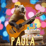 Animated birthday GIF showing a capybara playing guitar and singing beside a birthday cake with the name Paula in large letters and colorful bokeh lights in the background.