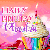A vibrant birthday GIF featuring a rainbow-colored cupcake topped with white frosting, sprinkles, and a lit candle. The text reads 'Happy Birthday Phaidra' in bold pink and violet letters with white outline.