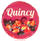 Beautifully decorated red velvet berry birthday cake with vibrant fruits and a glowing 'Quincy' name, adding a touch of sweetness and sparkle.
