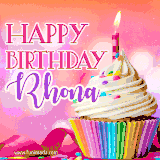 A vibrant birthday GIF featuring a rainbow-colored cupcake topped with white frosting, sprinkles, and a lit candle. The text reads 'Happy Birthday Rhona' in bold pink and violet letters with white outline.