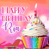 A vibrant birthday GIF featuring a rainbow-colored cupcake topped with white frosting, sprinkles, and a lit candle. The text reads 'Happy Birthday Ria' in bold pink and violet letters with white outline.