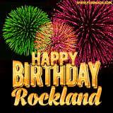 A captivating GIF with bursts of green, pink, and orange fireworks lighting up the night sky, accompanied by 'Happy Birthday Rockland' in glowing golden text.